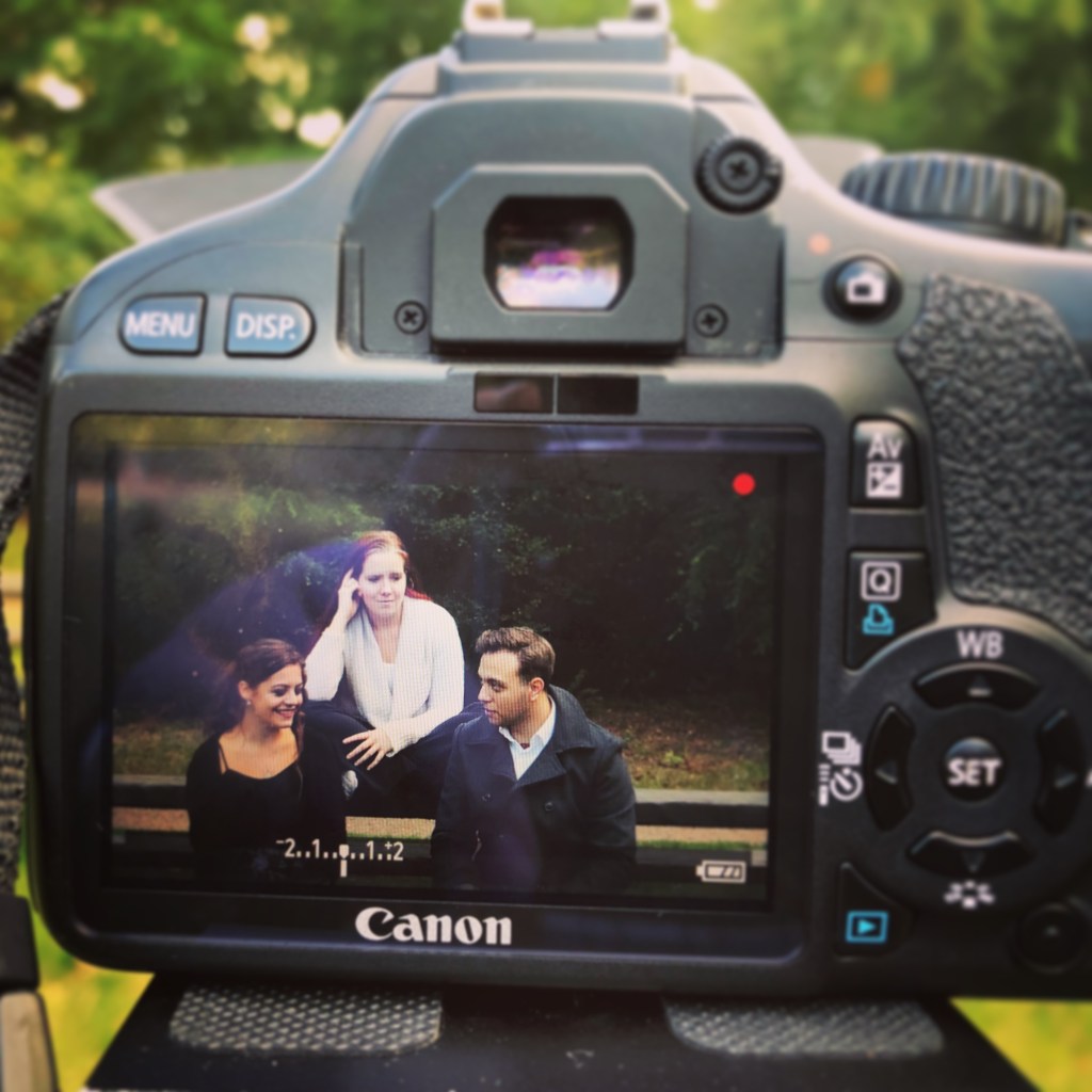 image is of the behind the scenes of filming web series Ghost Girl. Pictured is a DSLR Canon camera and on it's screen is the lead three actors, Janetta Ivanova, Emma Natasha Mills and Connor Croucher, during a scene. Picture is used to mirror the text about production company Moonchild Pictures